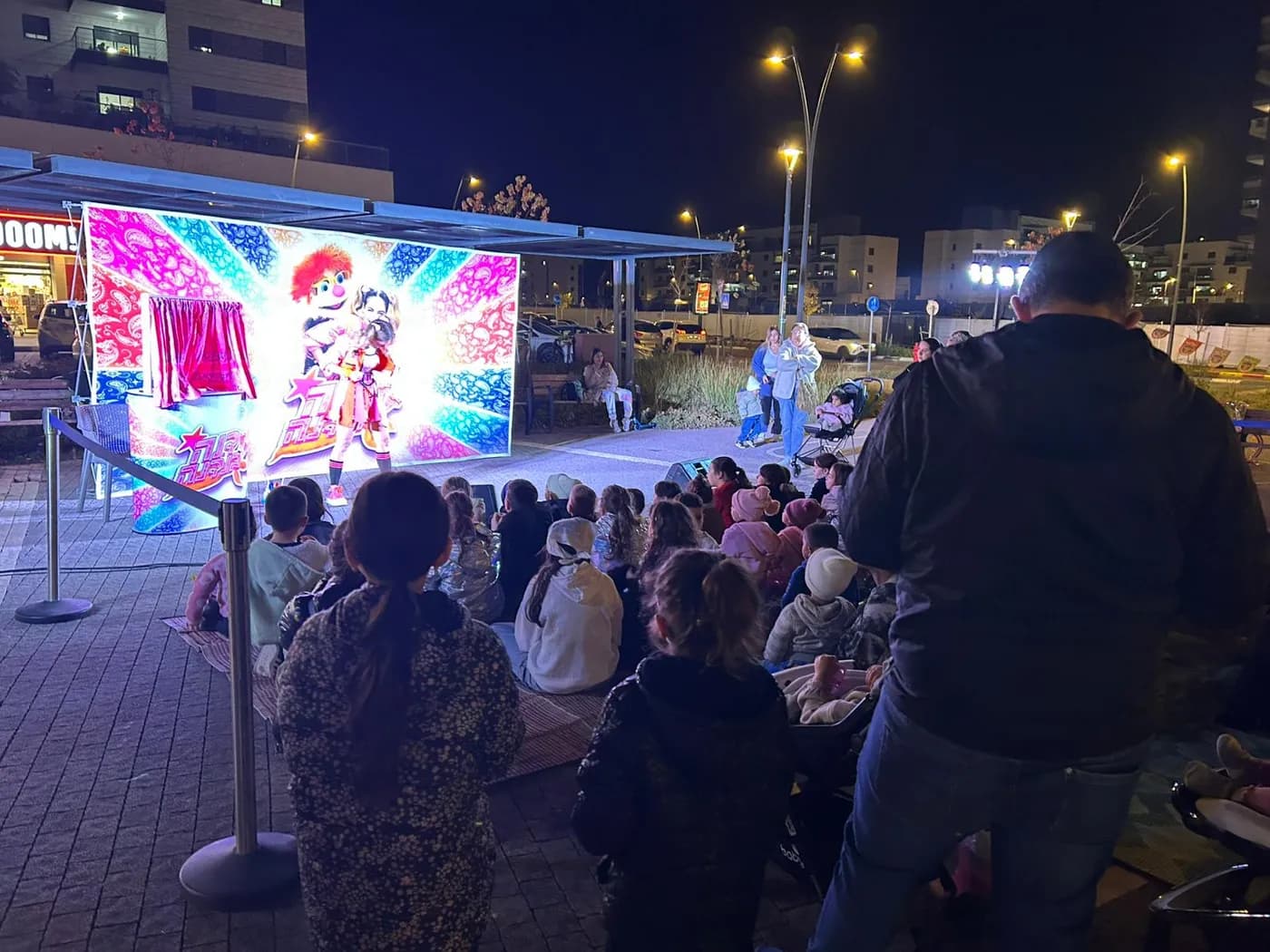 Families from the complex watching a performance in the square